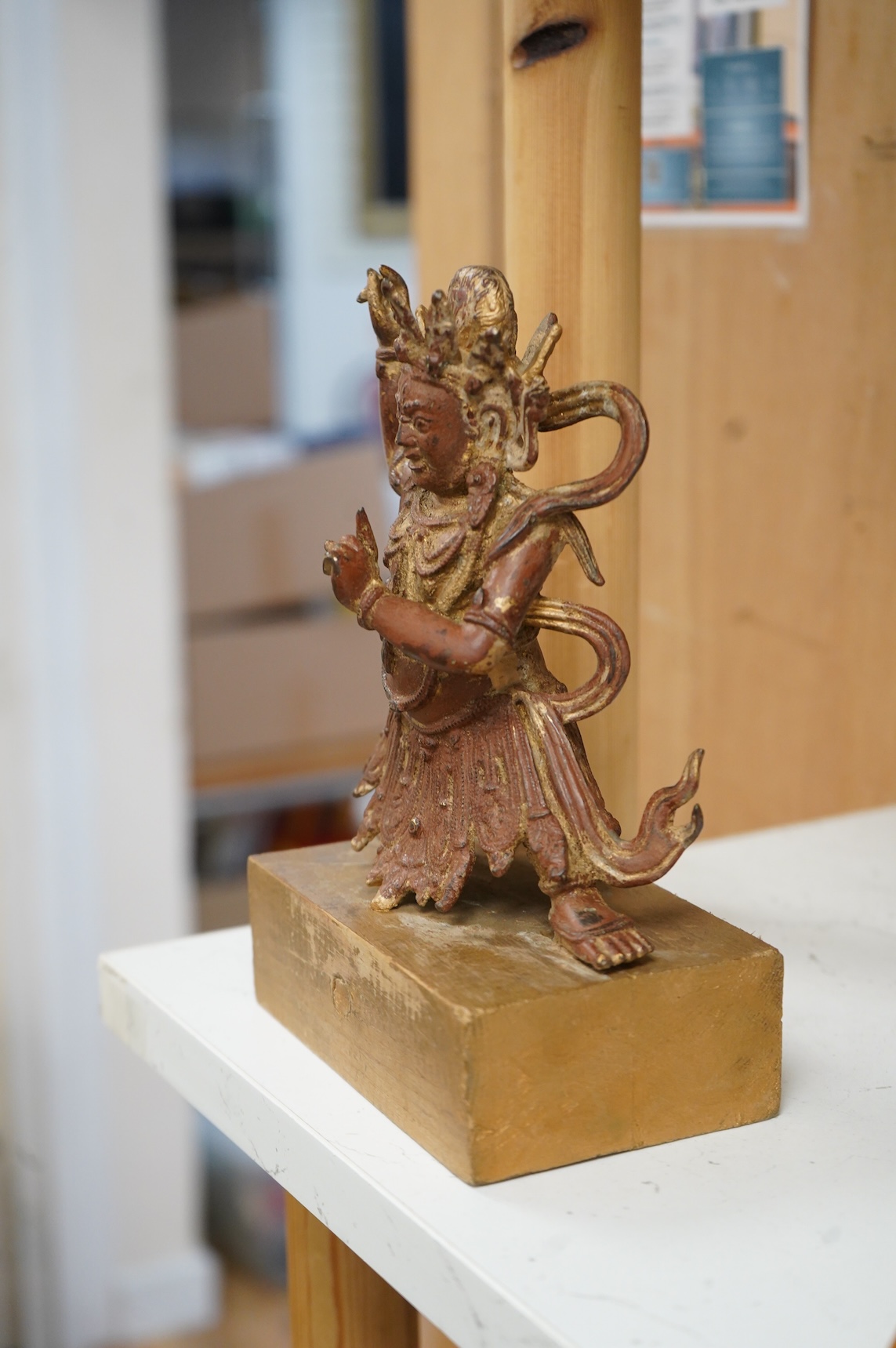 A Buddhist gilt bronze figure of Vaishravana, possibly Tibetan, 21 cm including wooden stand.